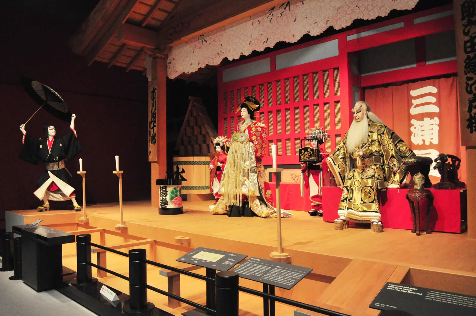 A traditional Japanese Kabuki scene, which originated the phrase ohayou gozaimasu, is displayed in the Edo-Tokyo Museum. It shows three people in different poses, wearing elaborate clothing.